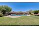 Lush backyard featuring a sparkling pool with water feature, manicured lawn, and beautiful landscaping at 11875 W Lone Tree Trl, Peoria, AZ 85383