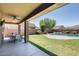 Outdoor patio with dining set overlooks a beautiful pool and lush green lawn at 11875 W Lone Tree Trl, Peoria, AZ 85383