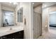 Well-lit bathroom featuring a vanity, mirror, and shower with a patterned curtain at 11875 W Lone Tree Trl, Peoria, AZ 85383