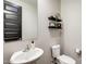 Powder room featuring a modern sink, toilet, vanity mirror and dark accent doors at 11875 W Lone Tree Trl, Peoria, AZ 85383