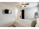 Well lit bedroom with a ceiling fan, TV, drawers and a mirror at 11875 W Lone Tree Trl, Peoria, AZ 85383