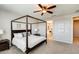 Bedroom features a four-poster bed, ceiling fan, and view to the en suite bathroom at 11875 W Lone Tree Trl, Peoria, AZ 85383