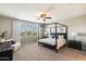 A cozy bedroom showcasing a four-poster bed, a ceiling fan, and a sunlit window at 11875 W Lone Tree Trl, Peoria, AZ 85383