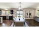 Open-concept dining area features hardwood floors, backyard views and access, complemented by modern lighting and stylish decor at 11875 W Lone Tree Trl, Peoria, AZ 85383
