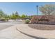 Stone Sunset Park entrance sign surrounded by desert plants and shrubs indicates neighborhood welcome at 11875 W Lone Tree Trl, Peoria, AZ 85383