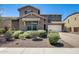 Charming two-story home with desert landscaping, a brick driveway, and a two-car garage, bathed in bright sunlight at 11875 W Lone Tree Trl, Peoria, AZ 85383
