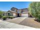 Two-story home with a three-car garage, brick driveway and stone accents, combining functionality with curb appeal at 11875 W Lone Tree Trl, Peoria, AZ 85383