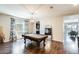 Spacious game room features a pool table, elegant lighting, and dark hardwood flooring at 11875 W Lone Tree Trl, Peoria, AZ 85383