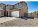 Side view of a home featuring a three-car garage, gravel landscaping, and a fenced in yard at 11875 W Lone Tree Trl, Peoria, AZ 85383