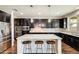 Beautiful kitchen features stainless steel appliances, granite counters, dark cabinets, and a center island with barstool seating at 11875 W Lone Tree Trl, Peoria, AZ 85383
