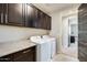 Beautiful laundry room featuring dark wood cabinets, counter space and modern washer and dryer at 11875 W Lone Tree Trl, Peoria, AZ 85383