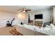 Spacious upstairs living area featuring a ceiling fan, television, white couch, and carpet at 11875 W Lone Tree Trl, Peoria, AZ 85383