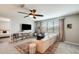Upstairs living area with large windows, ceiling fan, carpet flooring and a white couch at 11875 W Lone Tree Trl, Peoria, AZ 85383