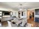 Spacious living area with hardwood floors, modern lighting, and an open layout seamlessly connecting to dining and kitchen spaces at 11875 W Lone Tree Trl, Peoria, AZ 85383