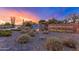 Scenic Vistancia community entrance with a waterfall, tranquil pond, and desert plants at dusk at 11875 W Lone Tree Trl, Peoria, AZ 85383