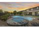 Gorgeous backyard features a refreshing pool and spa combination, complemented by lush landscaping and a sunset backdrop at 11875 W Lone Tree Trl, Peoria, AZ 85383