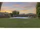Backyard featuring a sparkling pool, green lawn, and tranquil ambiance at 11875 W Lone Tree Trl, Peoria, AZ 85383