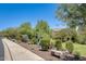 Well-maintained landscaping and a sidewalk create a welcoming streetscape, with a bench for resting at 11875 W Lone Tree Trl, Peoria, AZ 85383