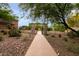Charming walkway with stone archway leading to a community area surrounded by lush desert landscaping at 11875 W Lone Tree Trl, Peoria, AZ 85383
