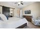 Spacious bedroom featuring a sliding barn door, dresser with TV, and a comfortable sitting area at 12027 S 183Rd Dr, Goodyear, AZ 85338