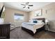 Comfortable bedroom featuring a ceiling fan, natural light, and a cozy seating area at 12027 S 183Rd Dr, Goodyear, AZ 85338