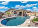 Relaxing backyard oasis with a sparkling pool, patio area, and mature landscaping at 12027 S 183Rd Dr, Goodyear, AZ 85338