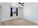 Inviting bedroom with neutral carpet, ceiling fan, and view of the neighborhood at 1215 E Geneva Dr, Tempe, AZ 85282