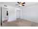 Clean bedroom with plush carpeting, ceiling fan, and access to closet space at 1215 E Geneva Dr, Tempe, AZ 85282
