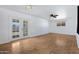 Bright living room featuring wood floors, ceiling fan and natural light through glass doors and window at 1215 E Geneva Dr, Tempe, AZ 85282