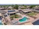 Aerial view of a backyard with a custom pool, lush lawn, and a covered patio area for outdoor enjoyment at 15019 W Banff Ln, Surprise, AZ 85379