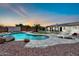 Beautiful backyard featuring a custom-designed pool, ample space for lounging, and lovely sunset views at 15019 W Banff Ln, Surprise, AZ 85379