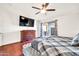 Primary bedroom with dark wood floors, ceiling fan, decorative curtains, and sliding glass door to the patio at 15019 W Banff Ln, Surprise, AZ 85379