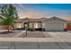 Inviting home with a well-lit exterior, a cozy front patio, and a convenient two-car garage at 15019 W Banff Ln, Surprise, AZ 85379