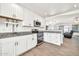 Bright kitchen with white cabinets, stainless steel appliances, granite countertops and wood-look tile at 15019 W Banff Ln, Surprise, AZ 85379