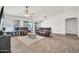 Spacious living room with tile floors, a ceiling fan, and sliding glass doors leading to the backyard at 15019 W Banff Ln, Surprise, AZ 85379