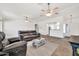 Spacious living room featuring two ceiling fans and an open view of the breakfast bar at 15019 W Banff Ln, Surprise, AZ 85379