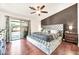Luxurious main bedroom featuring a tufted headboard, wood floors, and backyard access at 15019 W Banff Ln, Surprise, AZ 85379
