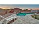Backyard with a custom pool and relaxing stone patio, offering a perfect outdoor retreat at 15019 W Banff Ln, Surprise, AZ 85379