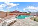Outdoor pool with waterfall feature, block fence surround, and a lounge chair at 15019 W Banff Ln, Surprise, AZ 85379
