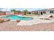 Backyard pool area with a rock feature and well-manicured landscaping at 15019 W Banff Ln, Surprise, AZ 85379