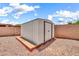 Backyard storage shed with wood foundation on a gravel lot, surrounded by a block fence at 15019 W Banff Ln, Surprise, AZ 85379