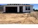 New home construction with an attached garage and materials staged on lot at 15793 W Beryl Ave, Waddell, AZ 85355