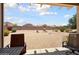 View of spacious backyard featuring desert landscaping and covered patio with comfortable seating area at 16222 W Silver Falls Dr, Surprise, AZ 85374