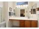 Well-lit bathroom featuring a long vanity with storage and mirror, alongside a toilet and shower at 16222 W Silver Falls Dr, Surprise, AZ 85374