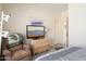 Comfortable bedroom featuring a recliner, TV, and a view of the hallway at 16222 W Silver Falls Dr, Surprise, AZ 85374