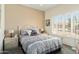 Bedroom with a metal frame bed, neutral colored walls and carpet, and shuttered window at 16222 W Silver Falls Dr, Surprise, AZ 85374