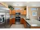 Well-equipped kitchen featuring stainless steel appliances, granite countertops, and warm wood cabinetry at 16222 W Silver Falls Dr, Surprise, AZ 85374