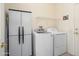 Functional laundry room equipped with a washer, dryer, storage cabinet, and shelving at 16222 W Silver Falls Dr, Surprise, AZ 85374