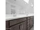 Modern bathroom showcasing double sinks with sleek faucets and dark wood cabinetry, complemented by a bright, spacious mirror at 16784 W Hope Dr, Surprise, AZ 85388