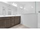 Bathroom featuring dual vanities, a modern shower with glass enclosure, and updated fixtures at 16784 W Hope Dr, Surprise, AZ 85388